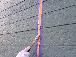 充填後はヘラで均して密着させます。外壁の仕上がり色に合わせてオレンジ色のコーキング剤を使用しました(^^)