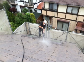 屋根の高圧洗浄作業！コケが少ないので滑りませんが勾配があるので注意しながら作業！