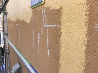 外壁中塗り塗装中。モルタル外壁では仕方ない部分もありますが、ひび割れが多めでした。